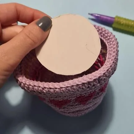 Crochet pot base with round cardboard insert used to stabilize the bottom