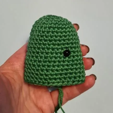 Close-up of green crocheted cactus body with embroidered facial details