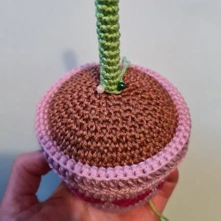Crocheted green flower stalk attached to the pot with internal support