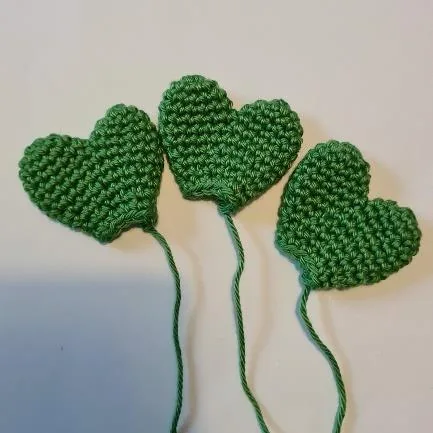 Green heart-shaped crocheted cactus thorns displayed before assembly