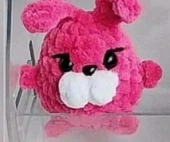 Pink mini crochet bunny with long raised ears and white muzzle