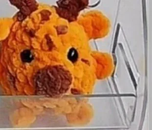 Orange mini crochet giraffe with brown spots and horns